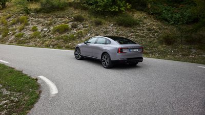 Volvo ES90 von hinten, der eine Bergstraße hinauffährt.