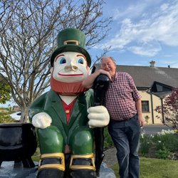 Mann lehnt an einer Koboldfigur