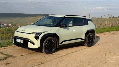 Kia EV3 parkt vor einem Weinberg. 