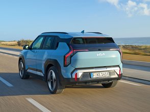 Blauer Kia EV3 fährt auf einer Küstenstraße. 