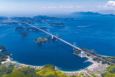 Eine lange Brücke spannt sich von einer Küste über ein Meer und verbindet dabei mehrere Inseln.