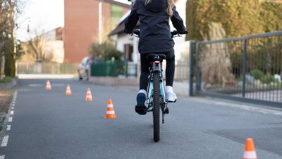 Ein Kind fährt durch einen Fahrradsicherheitsparcours.