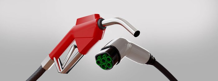 E- Auto Stecker neben Zapfpistole von Verbrenner.