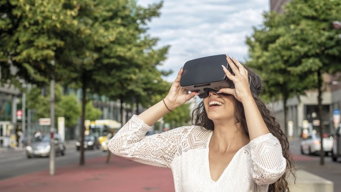 Eine junge Frau testet eine VR-Brille.