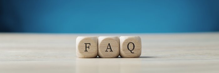 Drei Holzwürfel mit den Buchstaben F, A und Q liegen auf einem Tisch.