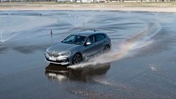 Auto, welches auf einer nassen Fahrbahn fährt.
