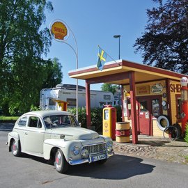 Volvo Oldtimer vor einer alten Shell Tankstelle.
