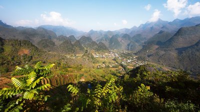 Blick in eine grüne Berglandschaft, aus der zahllose Hügel hervorragen.