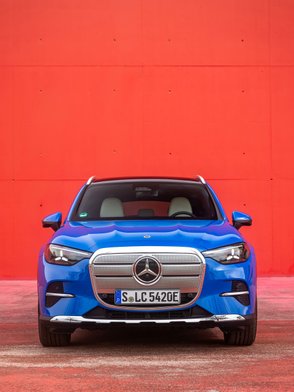 Mercedes GLC 400 4-Matic Elektro von vorne vor einer roten Wand.