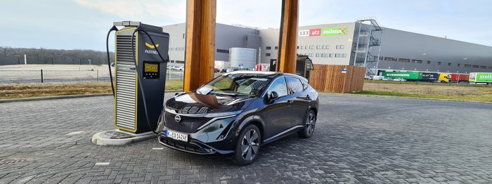 Ein Nissan Ariya Evolve steht an einer Ladesäule.