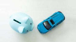 Spielzeugauto neben Sparschwein.