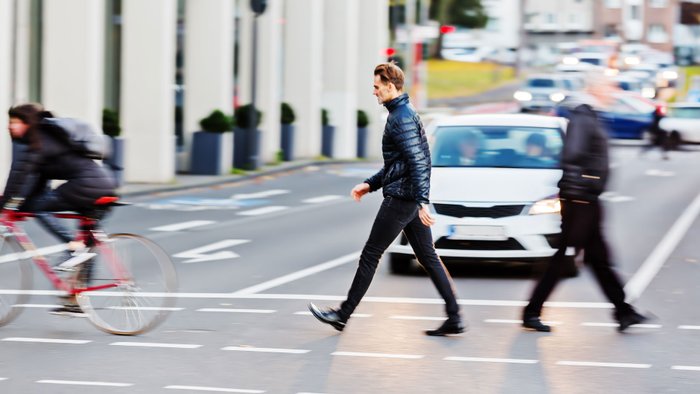 Fußgänger überquert Straße in der Stadt