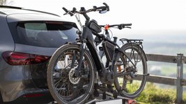 Pkw transportiert Fahrrad auf einem Fahrradträger auf der Anhängerkupplung.