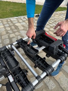 Mann zeigt auf eine Halterung eines Fahrradträgers.