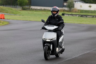 Eine Frau fährt einen Honda CUV e: auf einer Straße.