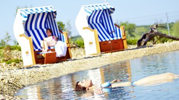 Zwei Strandkörbe mit Frauen an einem Salzsee.