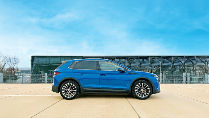 Skoda Elroq parkt vor einem futuristischen Gebäude