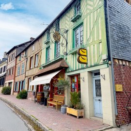 Straßenzug mit Fachwerkhäusern in verschiedenen bunten Farben.