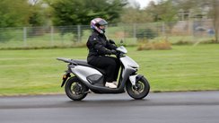 Eine Frau fährt den Elektroroller Honda CUV e