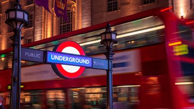 Bus fährt an einem U-Bahn-Zugang in London vorbei.