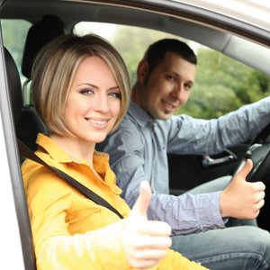 Frau und Mann im Auto, Daumen nach oben.