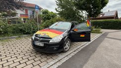 Ein Auto geschmückt mit Fanartikeln der Fußball-WM.
