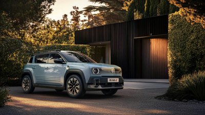 Renault 4 E-Tech steht vor einer Garage. 