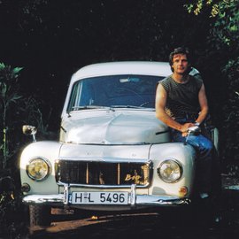 Mann sitz auf der Motorhaube eines Volvo Oldtimers.