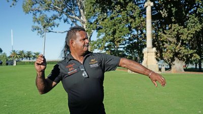 Mann wirft einen Boomerang in einem Park.