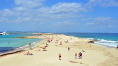 Blick auf eine Landzunge mit Sandstrand umgeben von türkisblauem Wasser.
