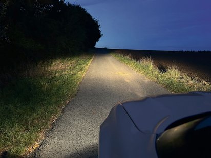 Halogener Scheinwerfer macht Licht auf einem Feldweg.
