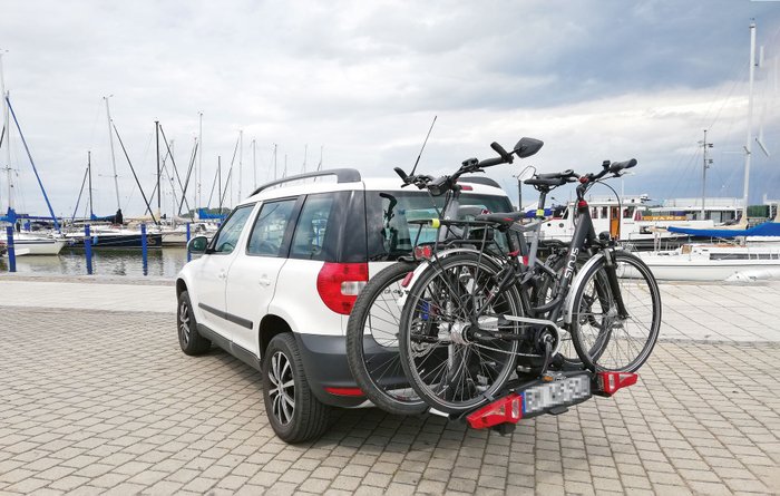 Weißes Auto am Hafen mit zwei Fahrrädern auf dem Fahrradträger.