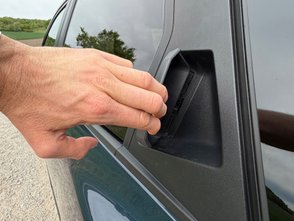 Mann öffnet die hintere Tür des Dacia Bigster. 
