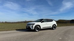 Renault Scenic E-Tech 220 parkt vor einem Feld. 