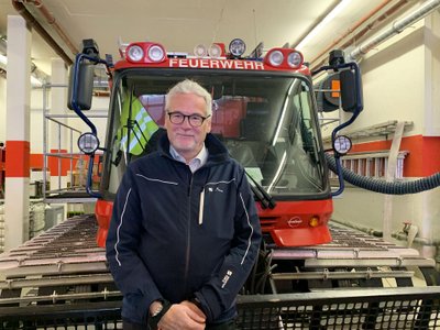 Bürgermeiser Gerhard Lucian vor dem Feuerwehrauto des Ortes.