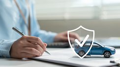 Eine Frau unterschreibt einen Kaufvertrag eines Autos. 