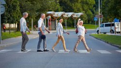 Passanten laufen über einen Zebrastreifen.