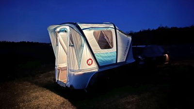 Urbanoid Booba aufgeklappt und beleuchtet bei Nacht.