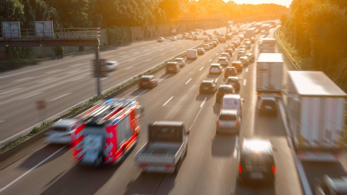 Ein Feuerwehrauto fährt durch eine Rettungsgasse auf der Autobahn. 