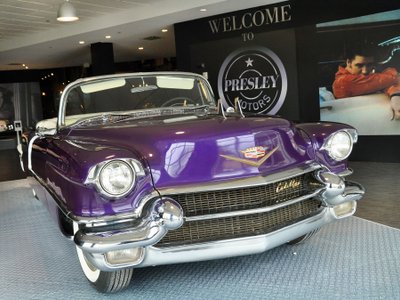 Lila Cadillac in Ausstellung vor einem Foto mit Elvis Presley.
