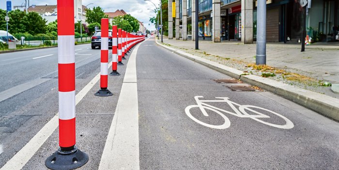Radfahrstreifen in einer Stadt abgegrenzt durch Poller.