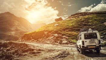 Ein Auto fährt durch eine bergige Landschaft.