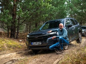 Wolfgang Sievernich kniet vor dem Subaru Forester. 