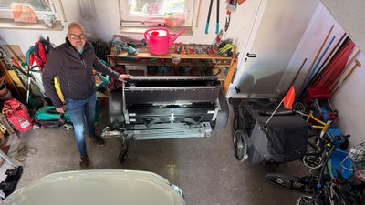 Wolfgang Sievernich steht mit dem Faltos-Anhänger in einer Garage. 