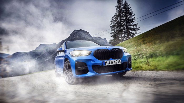 BMW X1 fährt über eine Bergstraße. 