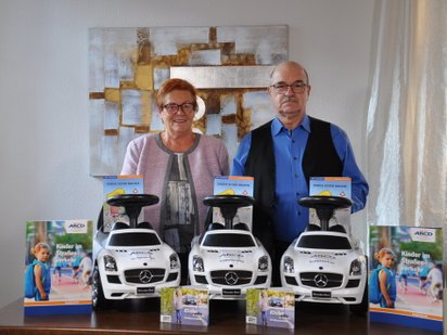 Zwei Personen, Rutschautos auf dem Tisch.