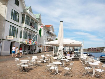 Uferpromenade mit weißen Holzhäusern und Cafés