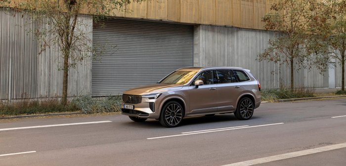 Volvo XC90 steht auf einer Straße vor modernem Gebäude.