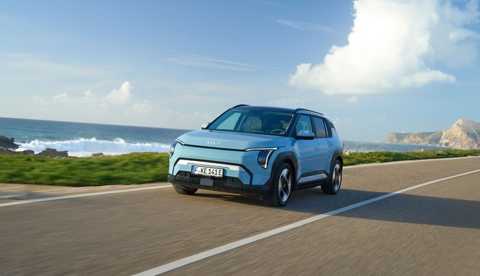 Blauer Kia EV3 fährt auf einer Straße