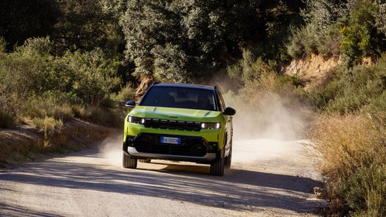 Jeep Compass fährt auf einem unbefestigten Weg.